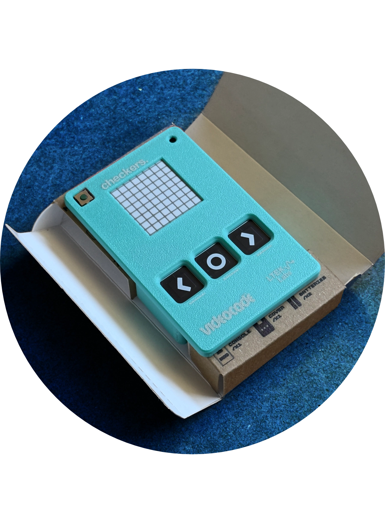 The teal VIDEOCADE checkers console resting in its open cardboard box